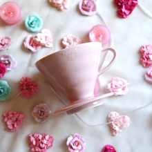 Görseli Galeri görüntüleyiciye yükleyin, Pembe Hario V60 02 seramik dripper, çiçekler ve kurabiyelerle masa düzeninde
