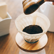 Görseli Galeri görüntüleyiciye yükleyin, Hario V60 Olive Wood cam drippera öğütülmüş kahve eklenmesi
